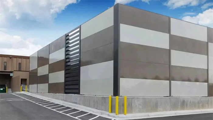 Quietline noise blocking barrier wall with acoustical louver around central plant.  Powdercoated steel in brown and white checkered pattern.