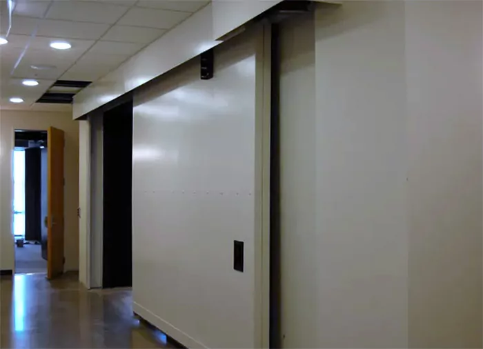 Interior QuietSlide motorized horizontal sliding acoustical elephant door to a theater.