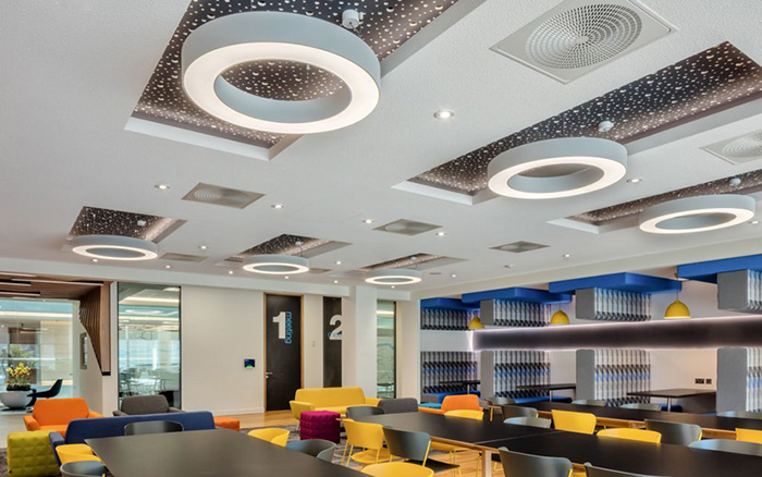 Black roll-painted Vogl acoustical drywall with a staggered perforation pattern in a library ceiling.