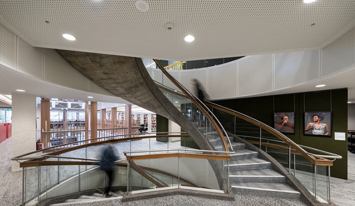 Perforated vogl acoustical drywall in a library stairwell.