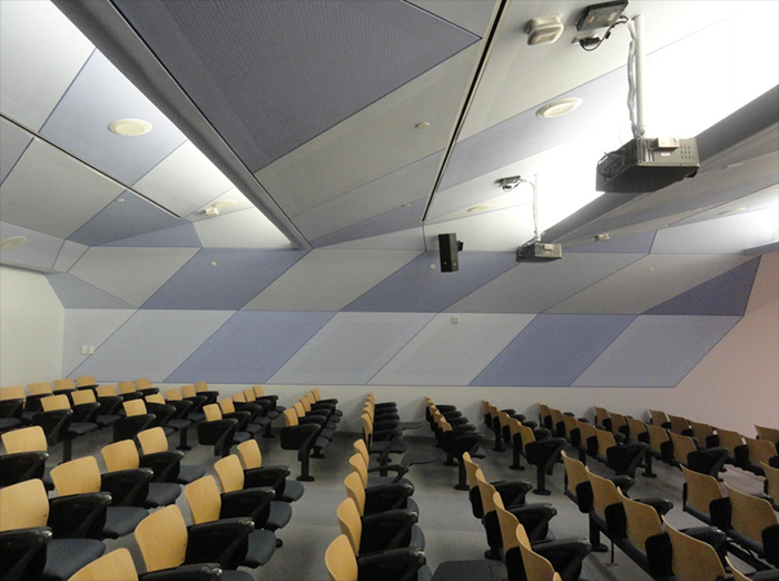 Vogl perforated drywall roll-painted in varying shades of blue in a university lecture hall.