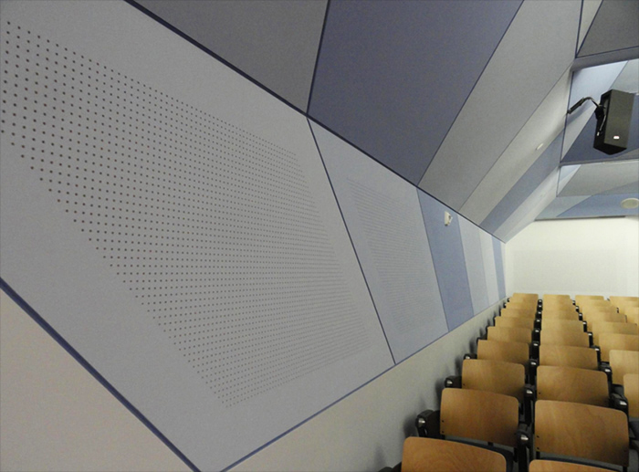 Close up of Vogl perforated drywall roll-painted in varying shades of blue in a university lecture hall.