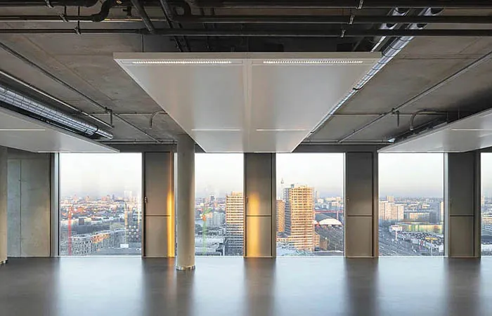 dur-solo metal ceiling clouds with integrated LED lights installed above a conference table in an exposed concrete ceiling