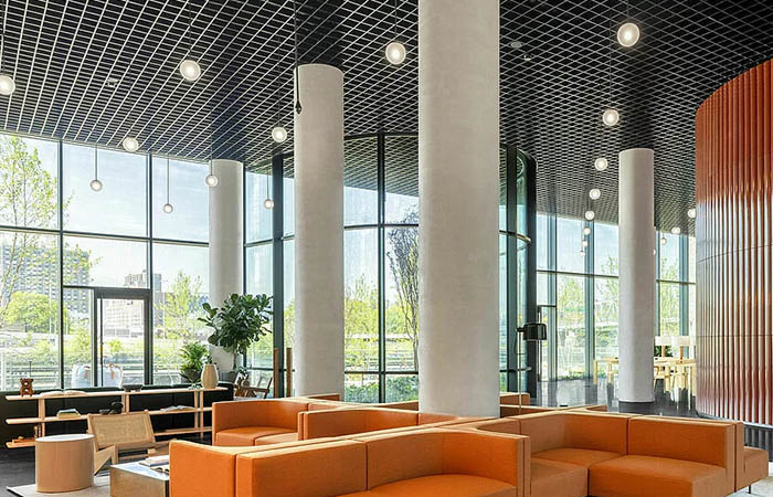 Rectilinear metal open cell ceiling grid in a hotel lobby.