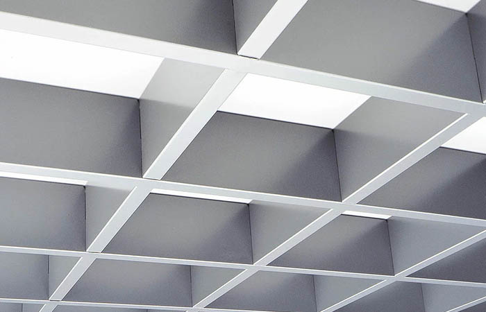 Detailed view of a double-wall rectangular grid open cell metal ceiling in white coated finish
