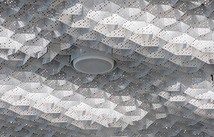 Quadra Decor powdercoated metal perforated open cell ceiling with speaker integration and light diffusion
