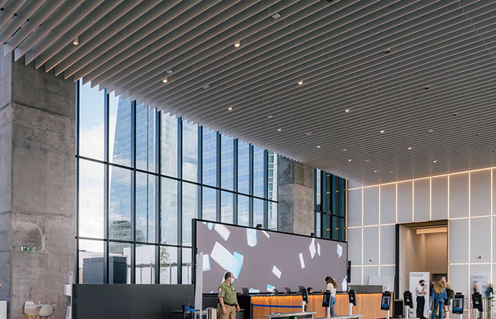 White perforated metal polylam acoustical baffles by durlum in a building atrium.