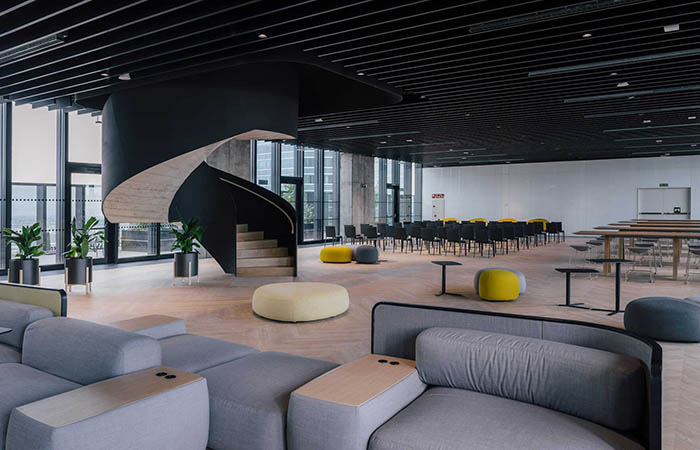 Black linear metal baffles in a multi-purpose lecture and exhibition space.