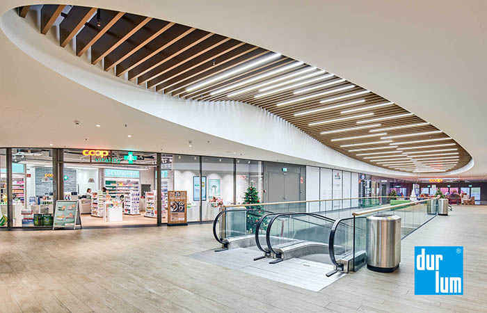 Wood appearance metal acoustical baffles in a shopping mall circulation area.
