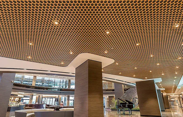 loop open cell metal ceiling in bronze powdercoat with downlights in hotel circulation