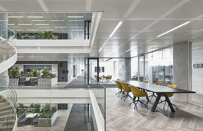 Metal perforated acoustic ceiling tiles in an open plan office with lighting integrations.