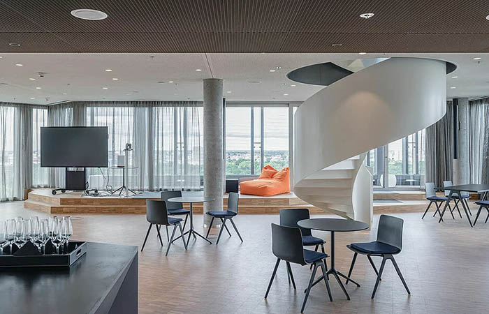 Expanded metal mesh ceiling in a multi function space with spiral stairs.