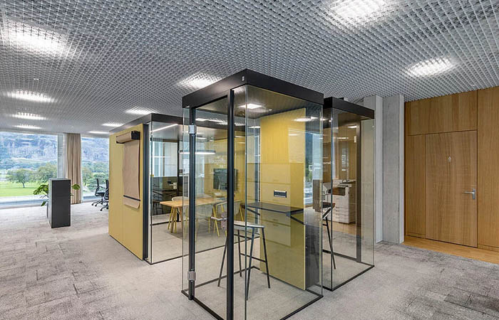 Ticell metal ceiling in an open office above phone rooms and breakout rooms.